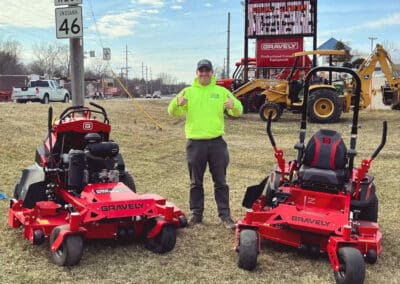 Anthony from Anthony's Lawn Care stands outside TrueValue Hardware in Ellettsville with two ride-on mowers