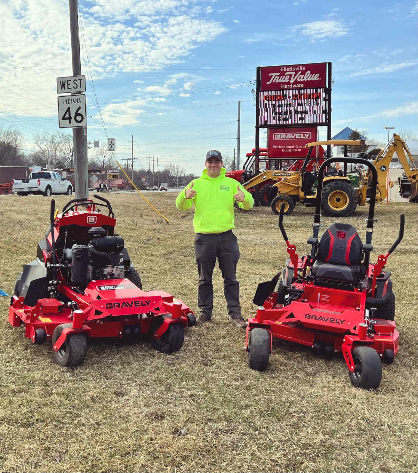 Anthony from Anthony's Lawn Care stands outside TrueValue Hardware in Ellettsville with two ride-on mowers